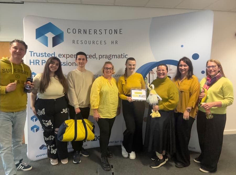 Cornerstone Resources team picture in the office with everyone wearing yellow